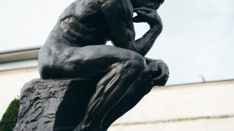 a statue of a man sitting on top of a cement block