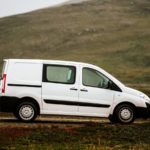 a white van parked on a dirt road